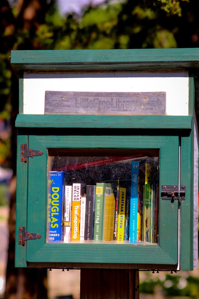 Discover a quaint Little Free Library displaying diverse books in a vibrant green box.